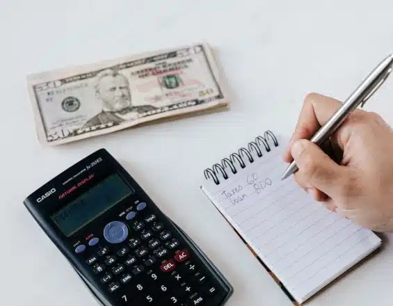 Crop anonymous financier planning budget writing numbers in notebook