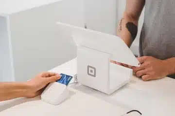 person using white tablet computer on table